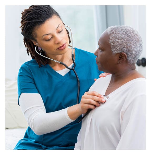 Home caregiver nurse examines elderly patient