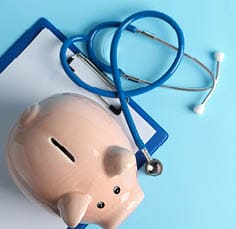 Stethoscope and piggy bank on blue background, space for text