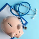 Stethoscope and piggy bank on blue background, space for text